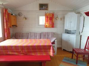 a small bedroom with a bed and a kitchen at Nestorin maja in Puumala