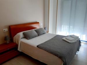 sypialnia z łóżkiem z dwiema poduszkami i oknem w obiekcie APARTAMENTO LA PERLA w mieście Portonovo
