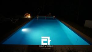 uma piscina azul iluminada à noite em Casa Do Colipo na Batalha