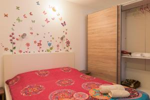 a bedroom with a red bed with butterflies on the wall at Center Walking Apartment and Room in Bucharest