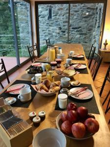 uma longa mesa de madeira com comida em Chambres d'hôtes Mas La Tardosse em Prats-de-Mollo-la-Preste