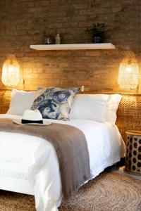 a bedroom with a bed with white sheets and pillows at Blaauw Cottage in Riebeek-Kasteel