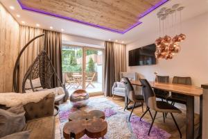 a living room with a table and chairs and a dining room at Quality Hosts Arlberg - ALPtyrol Appartements in Sankt Anton am Arlberg