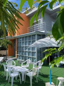 a group of white chairs and an umbrella in front of a building at Villa Bunmark in Sirindhorn