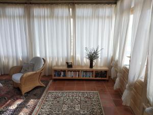 a living room with white curtains and a chair and a table at Villa El Perinqué in Femés