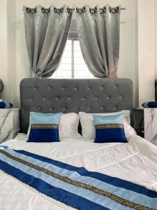 a bed with blue and white pillows and a window at Villa Bunmark in Sirindhorn