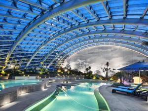 a large indoor swimming pool with a domed ceiling at InterContinental Resort Jiuzhai Paradise by IHG in Jiuzhaigou