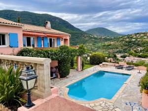 a villa with a swimming pool and a house at Vue mer & piscine T2 climatisé à Cavalaire in Cavalaire-sur-Mer