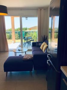 sala de estar con sofá y mesa en Mini-villa mitoyenne de type F2 proche Golfe de Lava en Appietto