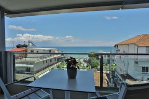 a table on a balcony with a view of the ocean at Alarzo Rooms in Paralia Katerinis