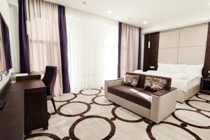 a hotel room with a bed and a couch at East Palace Hotel in Almaty
