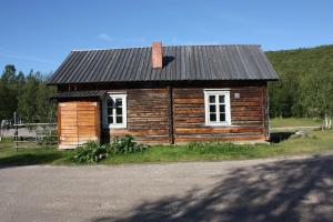 uma pequena casa de madeira com um telhado de estanho em Lapinkylä em Utsjoki