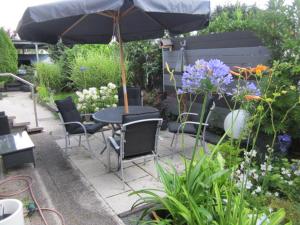 a table and chairs with an umbrella in a garden at Privatunterkunft Schonlau in Oberasbach