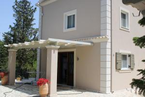 Biały dom z białą pergolą w obiekcie Luxury Villa Breeze with Private Pools w mieście Dassia