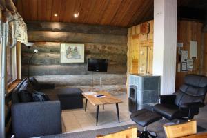 ein Wohnzimmer mit einem Sofa, einem Tisch und einem TV in der Unterkunft Osman Kelohovi in Utsjoki