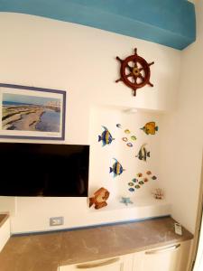 a room with a tv and a wall with fish decals at Rifugio Del Generale - comfort & relax in Pizzo