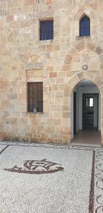 a stone building with a door and a tile floor at Lindos Center Studios in Líndos