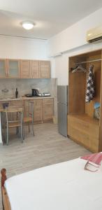 una cocina con armarios de madera, mesa y sillas en Lindos Center Studios, en Lindos