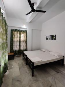 een slaapkamer met een bed en een plafondventilator bij Andoor Homes, Apt 2D in Trivandrum