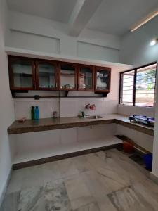 een keuken met houten kasten en een aanrecht bij Andoor Homes, Apt 2D in Trivandrum