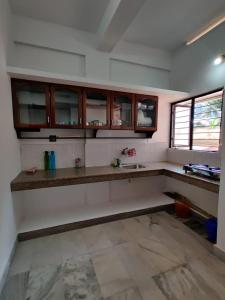 a kitchen with wooden cabinets and a counter top at Andoor Homes, Apt 2D in Trivandrum
