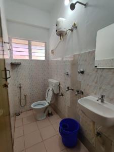 a bathroom with a toilet and a sink at Andoor Homes, Apt 2D in Trivandrum