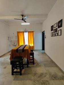 een eetkamer met een tafel en een plafondventilator bij Andoor Homes, Apt 2D in Trivandrum