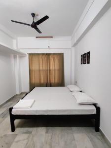 een bed in een kamer met een plafondventilator bij Andoor Homes, Apt 2D in Trivandrum