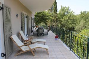 een patio met stoelen en tafels op een balkon bij VILLA Breeze in Dassia