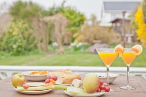 a table topped with two glasses of orange juice and fruit at Kents Bank Holiday - Pet Friendly with Bay Views in Grange Over Sands