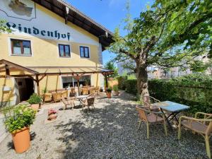 einen Tisch und Stühle vor einem Gebäude in der Unterkunft Hotel Pension Lindenhof in Prien am Chiemsee