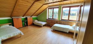 a bedroom with two beds and two windows at Vila Bělá pod Pradědem in Bělá pod Pradědem +21 photos