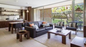 uma sala de estar com um sofá azul e uma mesa em Novo Apartamento T2 Herdade dos Salgados - Vila das Lagoas na Guia