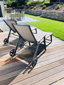 une chaise pliante assise sur une terrasse en bois dans l'établissement Ferienhaus Traumzeit, à NeuhÃ¼tten