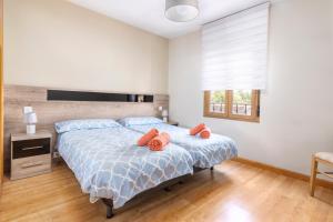 - une chambre dotée d'un lit avec des oreillers orange dans l'établissement Apartamento La Muralla - leonapartamentos, à León