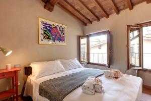 una camera da letto con un letto e asciugamani di Mamo Florence - Magazzini Apartment a Firenze