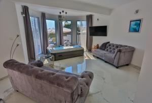 ein Wohnzimmer mit 2 Sofas und einem TV in der Unterkunft Villa Marin in Sevid
