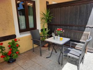 a table and chairs on a patio with flowers at Hotel Pension Lindenhof in Prien am Chiemsee