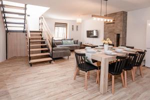 a dining room and living room with a table and chairs at Pasymianka House in Pasym