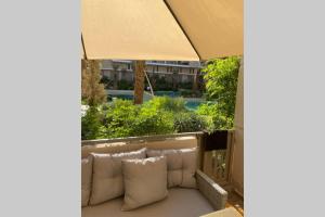 马拉喀什Cosy Duplex, dans résidence avec piscine的阳台上配有带枕头的沙发