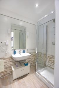 La salle de bains est pourvue d'un lavabo et d'une douche. dans l'établissement Green Oasis guesthouse, à Pompéi