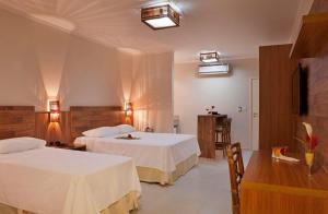 SalesにあるResort da Ilhaのベッド2台とテーブルが備わるホテルルームです。