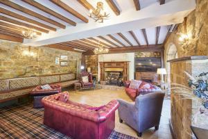 a living room with leather furniture and a stone wall at Host & Stay - The Arches Country House in Saltburn-by-the-Sea