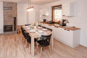 a kitchen and dining room with a wooden table and chairs at Pasymianka House in Pasym