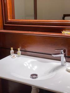 lavabo con espejo y lavabo blanco en Le NIL en Sainte-Anne