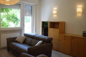 a living room with a couch and a large window at Casa Marina Giardino delle Rose in Marina di Carrara