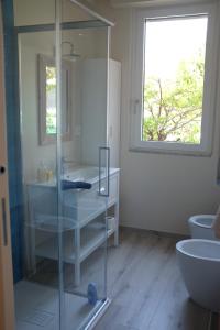 a bathroom with a glass shower and a sink at Casa Marina Giardino delle Rose in Marina di Carrara +27 photos