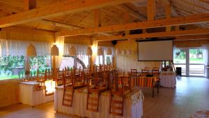 a room with tables and chairs and a screen at Apartamenty Pod Jesionem in Smołdzino
