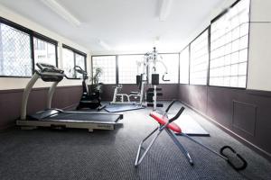 a gym with treadmill and elliptical machines and windows at Duke's Apartments in Perth