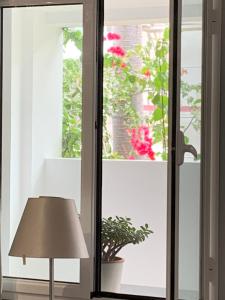 una stanza con una lampada e una finestra con fiori di Central - São Pedro Boutique a Funchal